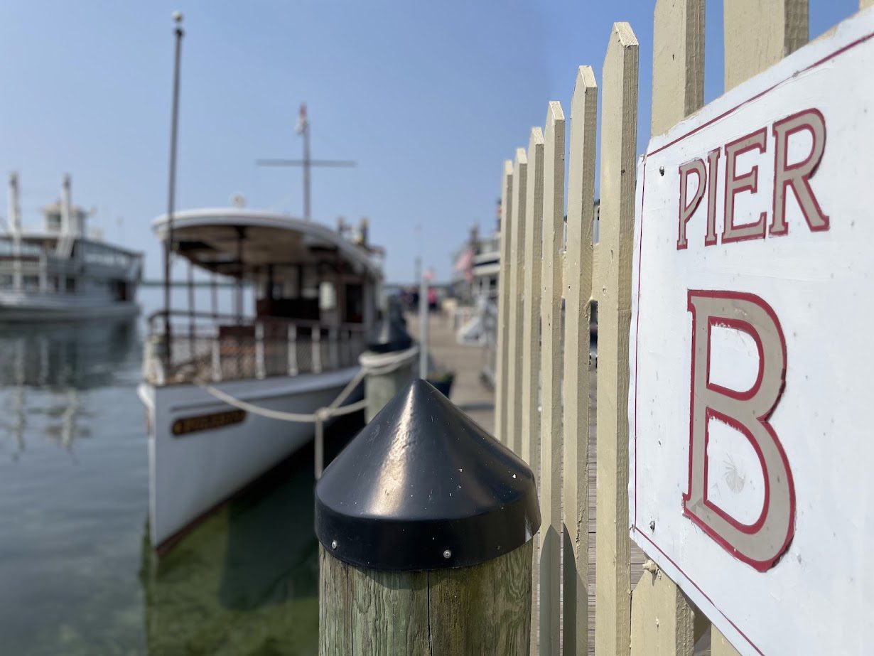 A docked boat near a fence with a Pier sign.