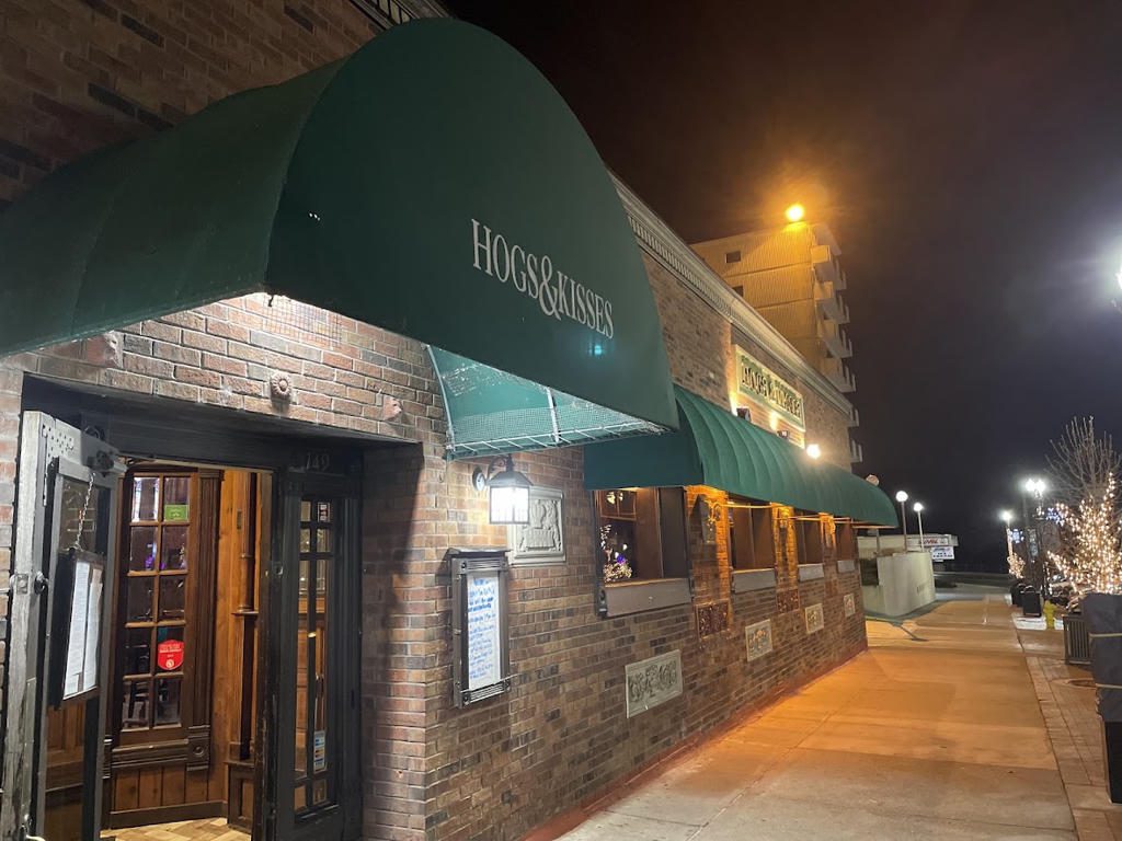 Exterior night view of a brick building with a green awning.