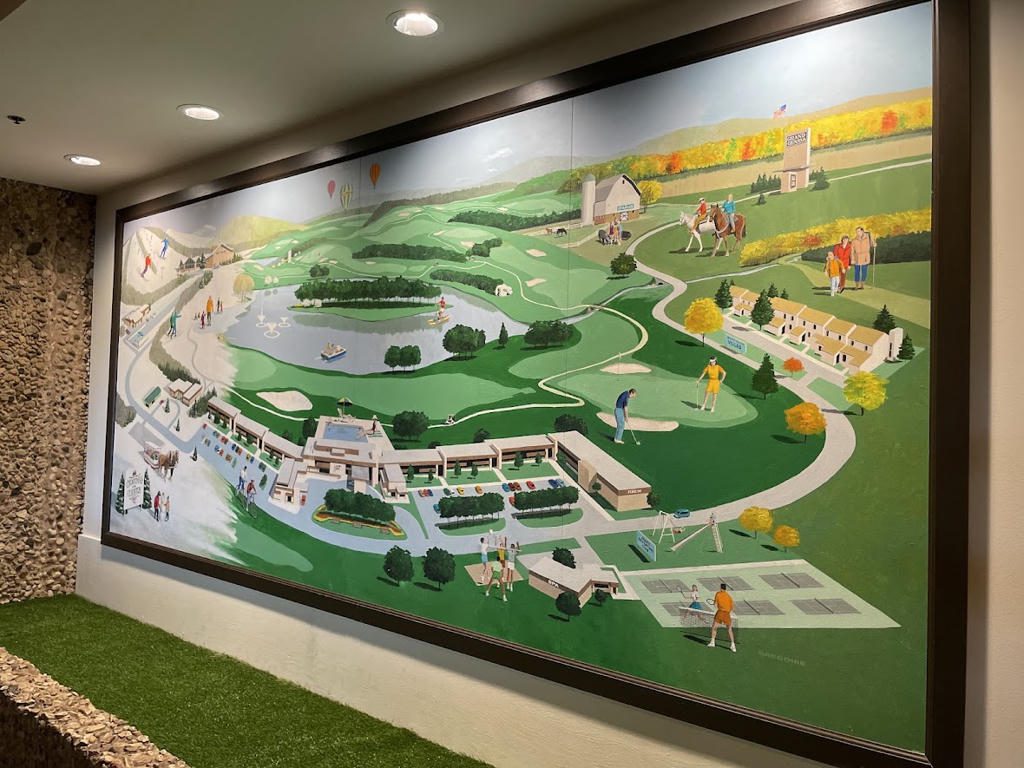 A colorful mural depicting a detailed landscape with buildings and greenery.
