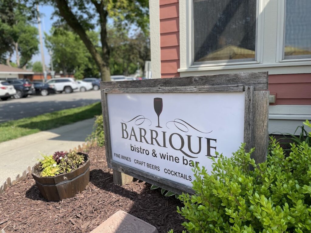 Sign for Barrique Wines & Wine Bar outdoors by a building.