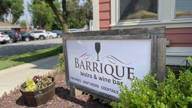 Sign for Barrique Wines & Wine Bar outdoors by a building.