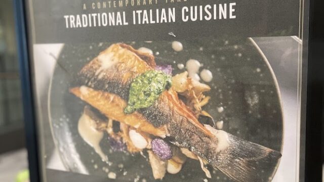 Signboard for Basilico Italian restaurant featuring traditional dishes and location info.