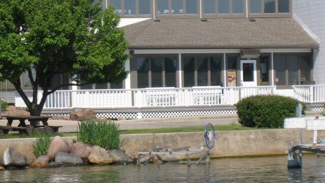 A lakeside building with a sign reading 'Chuck's' under a clear sky.