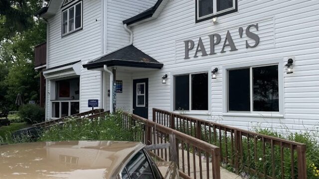 Exterior view of Papa's restaurant with a wheelchair ramp and parked car.