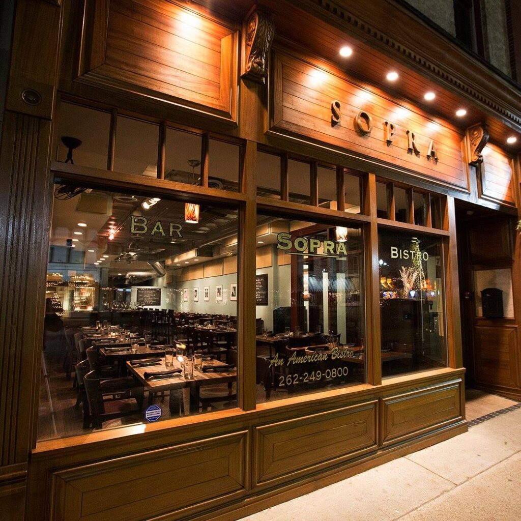 Cozy restaurant exterior with warm lighting at night.