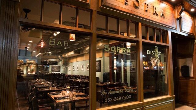Cozy restaurant exterior with warm lighting at night.