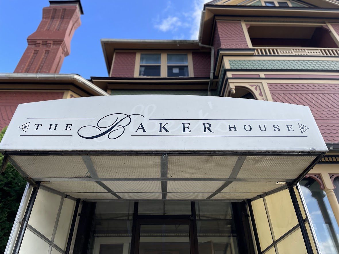 Facade of The Baker House with a white awning and clear blue sky.
