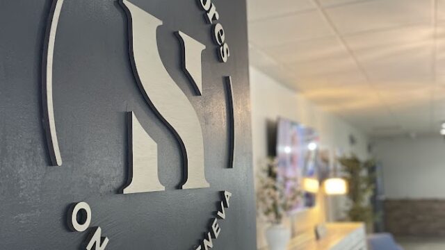 Interior wall with "Harbor Street on Lake Geneva" logo in a cozy room.