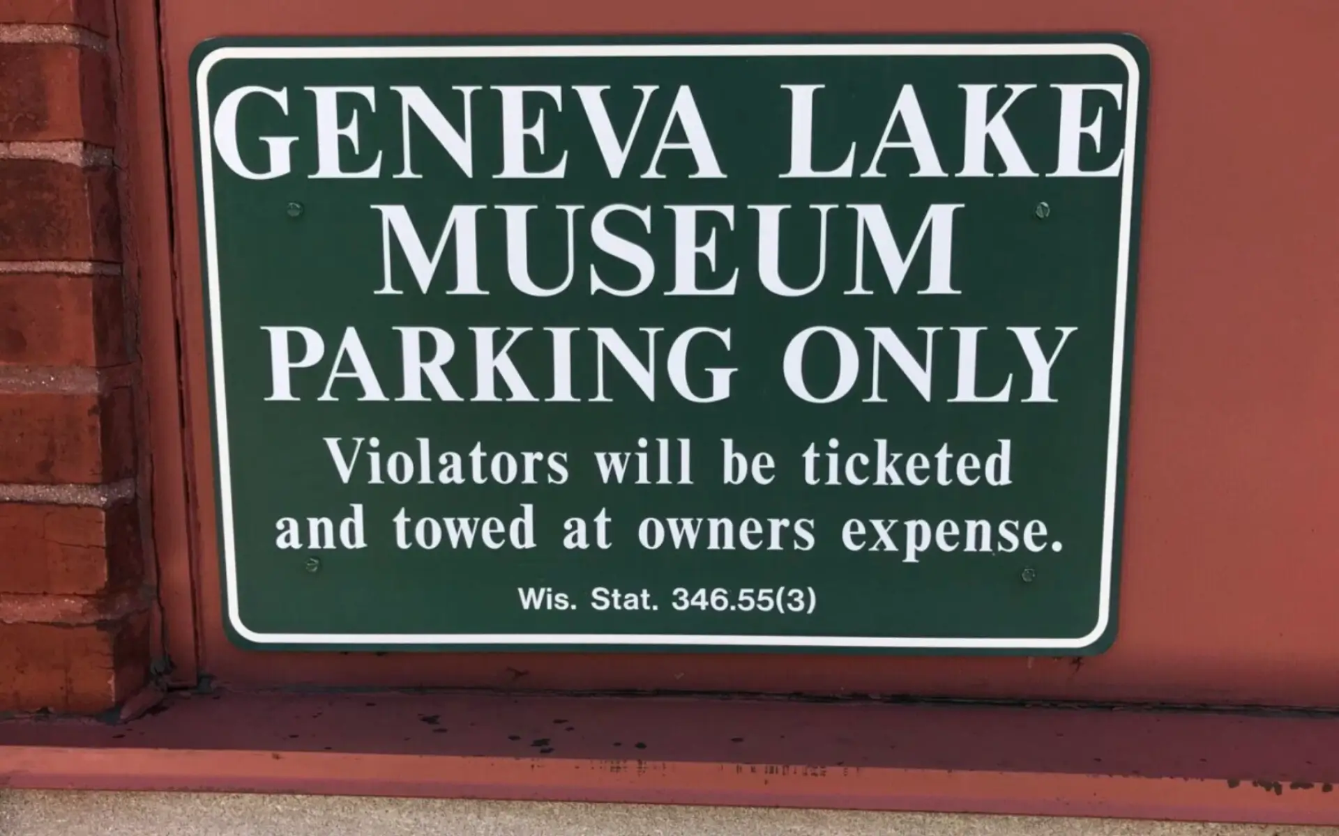 Sign reserving parking for Geneva Lake Museum visitors only.